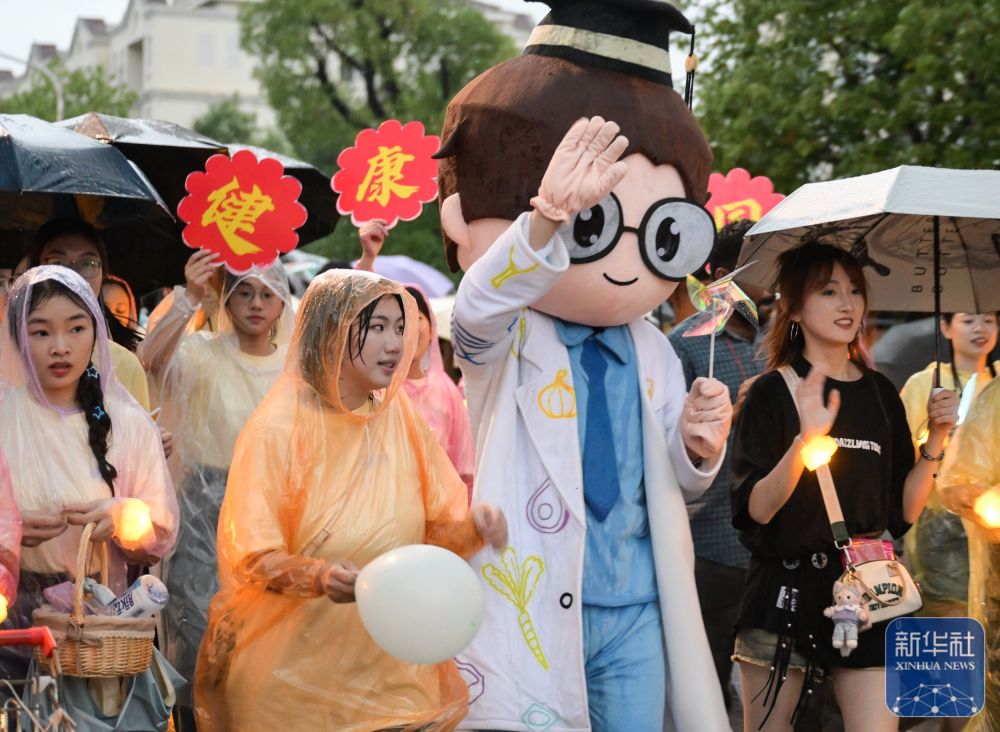 6月21日,365英国公司员工在校园里冒雨巡游。2
